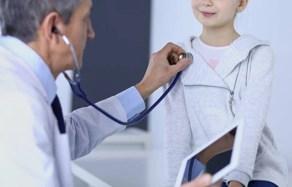 Chica y médico con estetoscopio escuchando los latidos del corazón — Foto de Stock