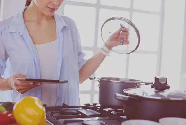 Giovane donna in piedi vicino al fornello in cucina — Foto Stock