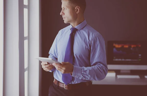 Le affärsman med pekplatta stående på arbetsplatsen på kontoret — Stockfoto