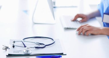 Masada oturan gülümseyen güzel genç bayan doktor.