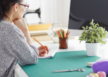 Güzel moda tasarımcısı stüdyoda duruyor.