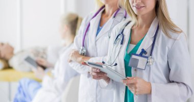 tıbbi ofiste geçti silah ile duran üç kendine güvenen kadın doktor portresi.