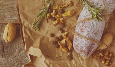 İtalyan salamı, deniz tuzu, biberiye, sarımsak ve fındık. Kırsal tarzda. Üst görünüm.