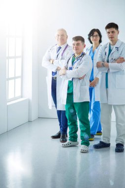 Başarılı tıbbi ekip. Kendine güvenen doktorlar bir arada durur ve gülümserler.