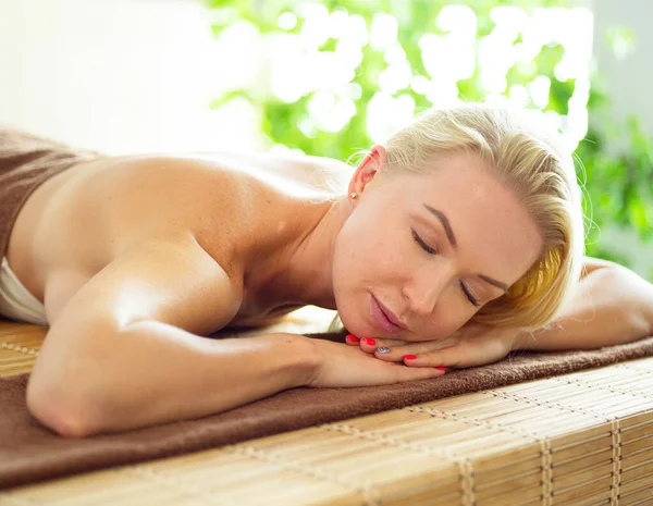 Beautiful young woman relaxing during full body massage at spa — Stock Photo, Image