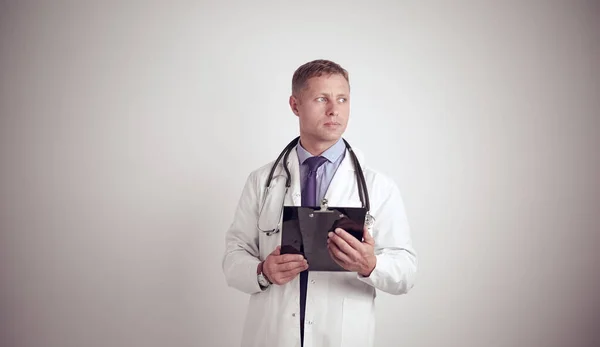 Άντρας γιατρός στέκεται με το φάκελο, απομονώνονται σε λευκό φόντο — Φωτογραφία Αρχείου