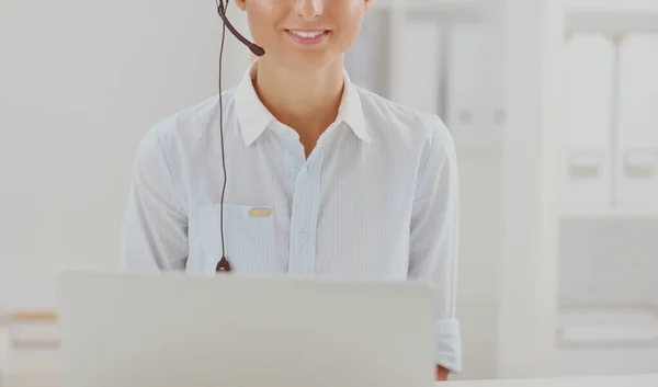 Portret van mooie jonge vrouwelijke operator zittend aan bureau met headset — Stockfoto