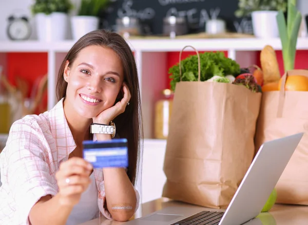 Donna sorridente shopping online con tablet e carta di credito in cucina. Donna sorridente — Foto Stock