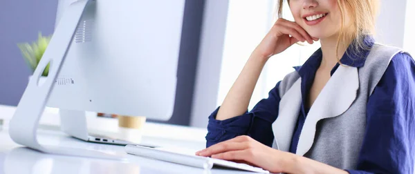 Joven empresaria confiada trabajando en el escritorio de la oficina y escribiendo con una computadora portátil — Foto de Stock