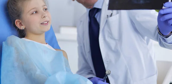 Niña sentada en el consultorio de dentistas —  Fotos de Stock