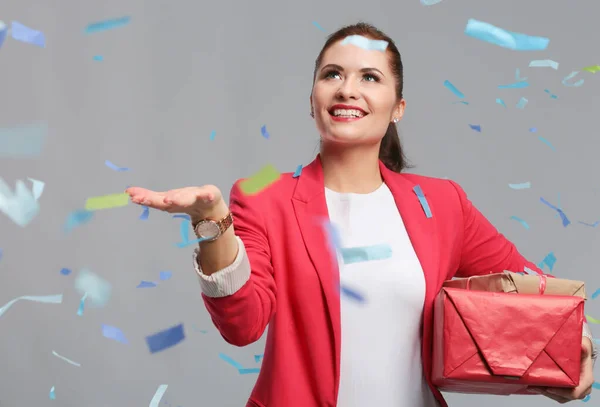 Mulher feliz bonita com caixa de presente na festa de celebração com confete. Aniversário ou véspera de Ano Novo celebrando conceito — Fotografia de Stock