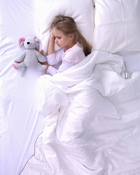 儿童小女孩睡在床上有一只玩具泰迪熊. — 图库照片