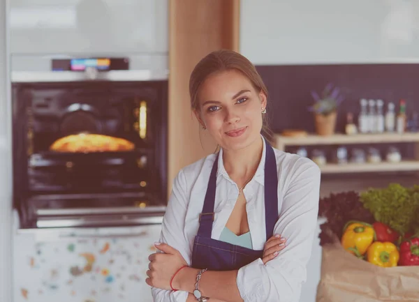 Portré fiatal nő álló karokkal keresztbe konyha háttér — Stock Fotó