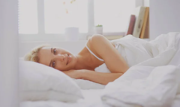 Mulher bonita deitada em sua cama em casa — Fotografia de Stock