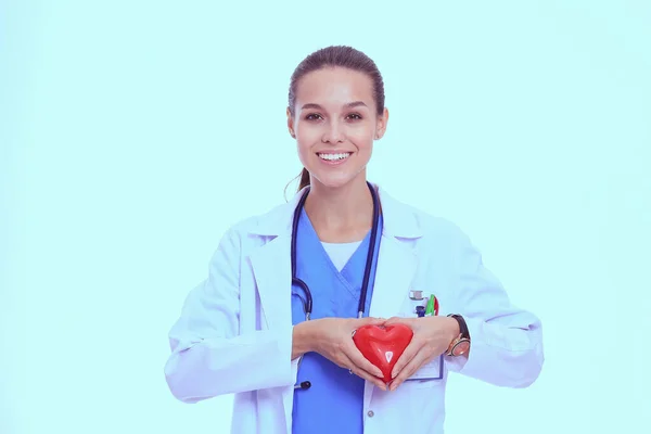 Beautiful smiling female doctor holding red heart and green apple. Woman doctor — Stock Photo, Image