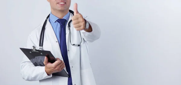 Ritratto di un bel dottore in mantello bianco con in mano una cartella, che mostra il segno Ok — Foto Stock