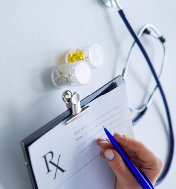 Kadınların elleri bir kağıt parçasına yazı yazıp masasında kalem bırakırlar.