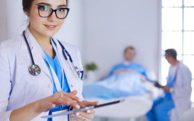 Hastane lobisinde tablet bilgisayar kullanan kadın doktor.