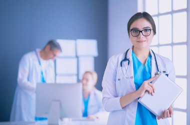Hastane lobisinde tablet bilgisayar kullanan kadın doktor.
