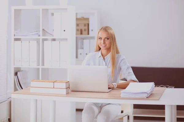 Портрет улыбающейся секретарши с помощью ноутбука и гарнитуры на рабочем столе — стоковое фото