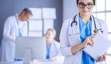 Hastane lobisinde tablet bilgisayar kullanan kadın doktor.