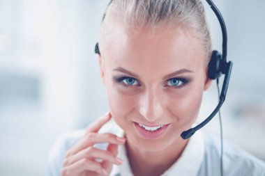 Ofis masasında oturan güzel bayan operatörün portresi.