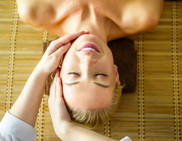 Young woman enjoying massage in spa salon — Stock Photo, Image