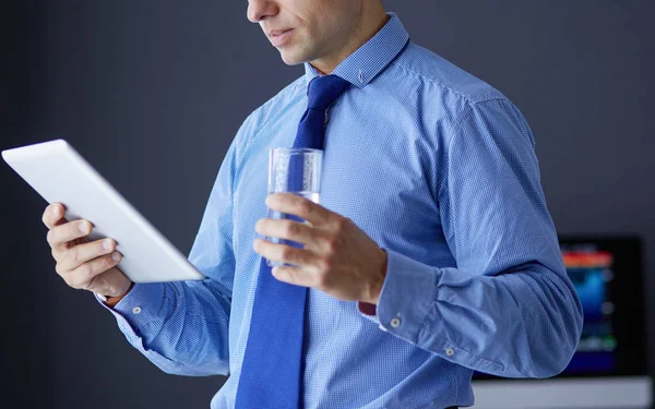 Junger seriöser Geschäftsmann mit Kopfhörer blickt auf Tablet-Bildschirm — Stockfoto