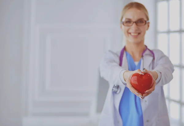 Médica com estetoscópio a segurar o coração nos braços. Conceito de saúde e cardiologia em medicina — Fotografia de Stock