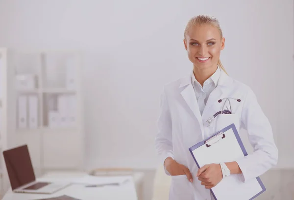 Una doctora sonriente con una carpeta de uniforme en el hospital. Médico sonriente —  Fotos de Stock