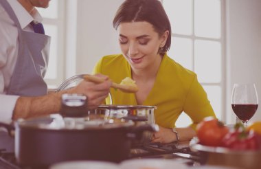 Evdeki mutfakta birlikte yemek pişiren çift.