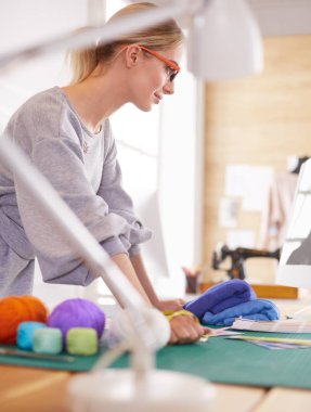 Moda tasarımcısı kadın stüdyoda tasarımları üzerinde çalışıyor.