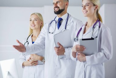 Meslektaşlarının önünde el sıkışan bir erkek doktor.