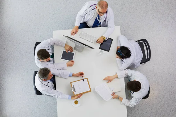 Medizinisches Team sitzt und diskutiert am Tisch, Draufsicht — Stockfoto