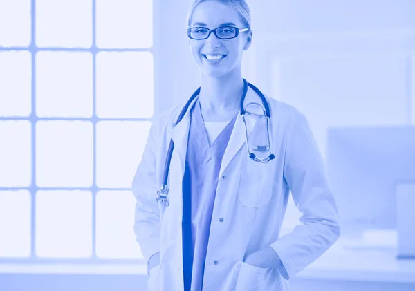 Jonge arts vrouw in de buurt van tafel, geïsoleerd op witte achtergrond — Stockfoto