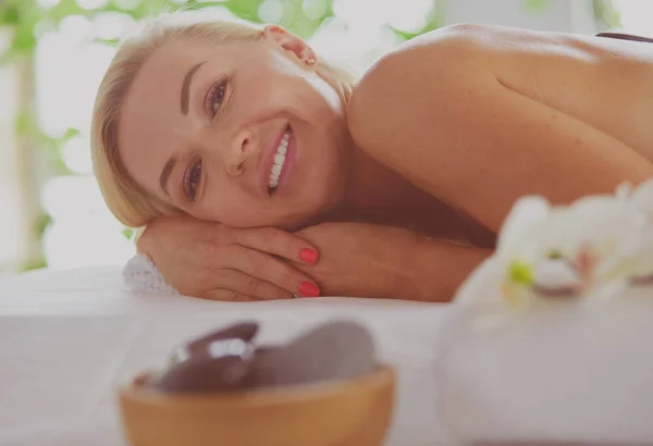 Hermosa mujer spa tumbada sobre una toalla en el salón de spa —  Fotos de Stock