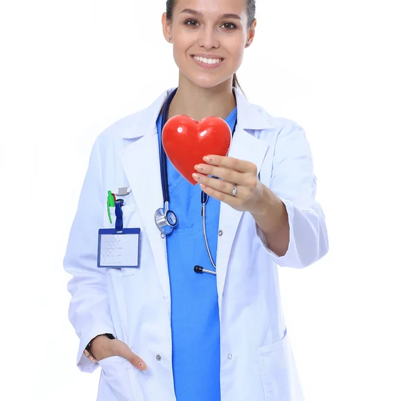 Medico femminile positivo in piedi con stetoscopio e simbolo del cuore rosso isolato. Donna medico — Foto Stock