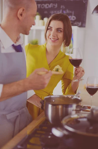 Atraktivní pár v lásce vaření a otevírá víno v kuchyni, zatímco oni vaří večeři pro romantický večer — Stock fotografie