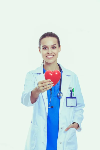 Positiva kvinnliga läkare står med stetoskop och red heart-symbolen isolerade. Kvinna läkare — Stockfoto