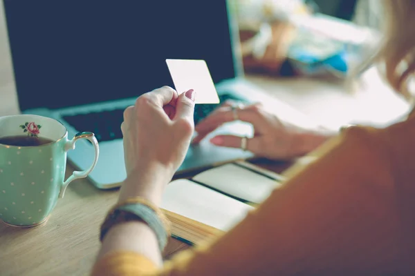 Jovem segurando cartão de crédito e usando computador portátil. Conceito de compras online — Fotografia de Stock