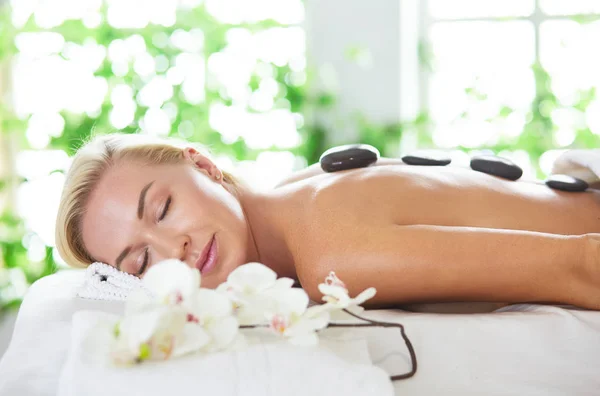 Jovem mulher desfrutando de massagem no salão de spa — Fotografia de Stock