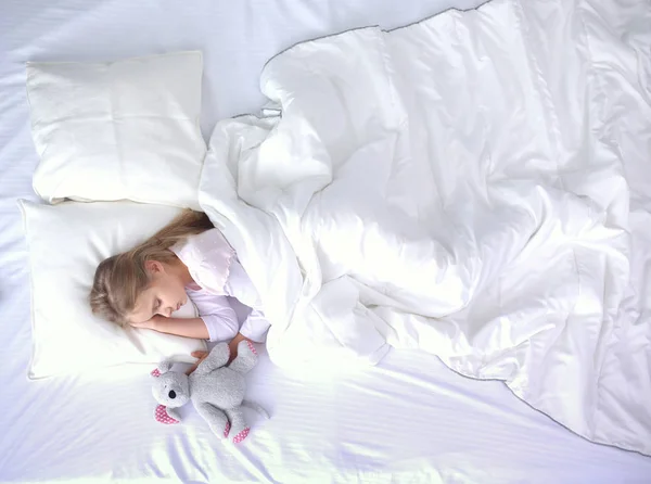 Bambino bambina dorme nel letto con un orsacchiotto giocattolo . — Foto Stock