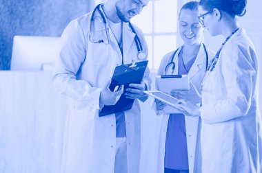 Bir grup doktor ve hemşire hastane odasında bekliyor.