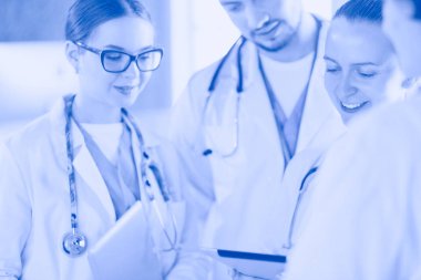 Doktor tabletinde tıbbi ekibine bir şey gösteriyor.