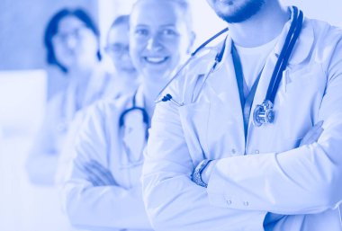 Erkek ve kadın doktorlardan oluşan mutlu tıbbi ekip geniş bir gülümseme ve başarı ve umut dolu bir onay veriyor.