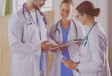 Doktor tabletinde tıbbi ekibine bir şey gösteriyor.