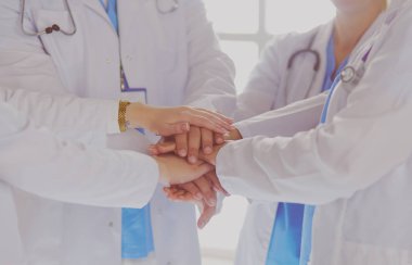 Doktorlar ve hemşireler el ele tutuşuyor. Beyazda izole edilmiş