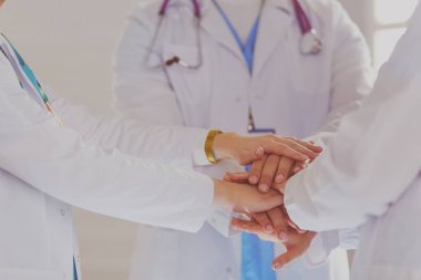 Doktorlar ve hemşireler el ele tutuşuyor. Beyazda izole edilmiş