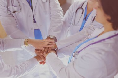 Doktorlar ve hemşireler el ele tutuşuyor. Beyazda izole edilmiş