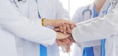 Doktorlar ve hemşireler el ele tutuşuyor. Beyazda izole edilmiş